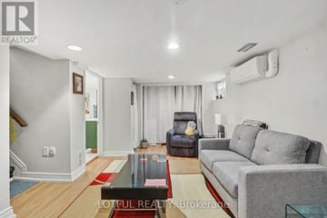 Ottawa apartment for rent - A living room with a grey couch and a red rug.