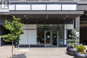Ottawa condo for rent - A modern building with glass doors and windows, with a tree in front and a bench to the left.