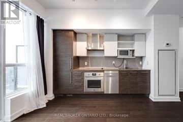 Toronto (Niagara) condo for rent - A modern kitchen with dark wood cabinets and stainless steel appliances.