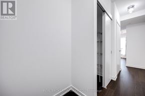 Toronto (Niagara) condo for rent - A hallway with a white wall and a glass door.