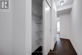Toronto (Niagara) condo for rent - A hallway with a refrigerator on the left and a door on the right.