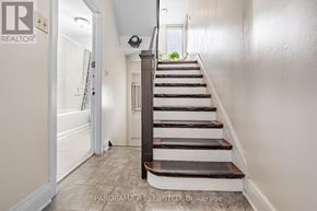 Toronto (Long Branch) apartment for rent - A staircase with a light brown wooden banister and white steps.