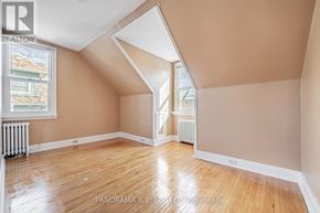 Toronto (Long Branch) apartment for rent - A room with wooden floors and a window with a view of a house across the street.