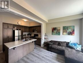 Hamilton (Stoney Creek) townhouse for rent - A kitchen with a refrigerator, sink, and cabinets is shown.