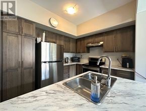 Hamilton (Stoney Creek) townhouse for rent - A kitchen with a marble countertop and a stainless steel refrigerator.