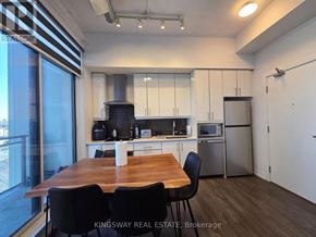 Toronto (Banbury-Don Mills) condo for rent - A kitchen with a table and chairs in front of a window.