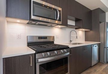 Surrey townhouse for rent - A modern kitchen with dark brown cabinets and stainless steel appliances.