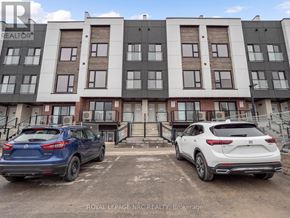 St. Catharines (E. Chester) townhouse for rent - Two cars are parked in front of a multi-story building.