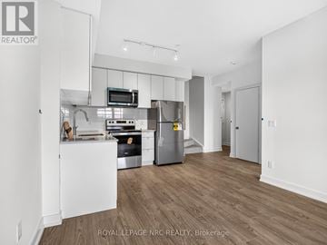 St. Catharines (E. Chester) townhouse for rent - A kitchen with white cabinets and a wooden floor.