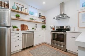 Toronto (Birchcliffe-Cliffside) apartment for rent - A modern kitchen with stainless steel appliances and white cabinets.