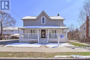 Oshawa (Central) triplex for rent - A house with a grey facade and a white fence.
