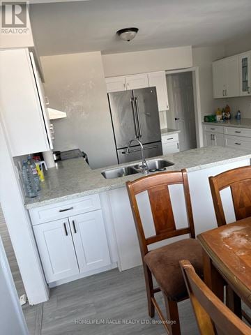 New Tecumseth apartment for rent - A kitchen with a sink, refrigerator, and cabinets.