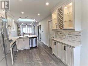 Toronto (Briar Hill-Belgravia) apartment for rent - A well-lit, modern kitchen with a refrigerator, stove, and cabinets.