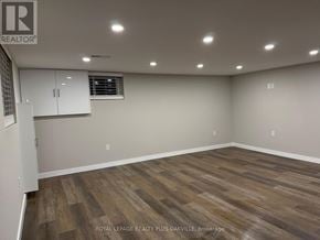 Hamilton (Mohawk) apartment for rent - A room with wooden flooring and white walls, with a window and a cabinet.