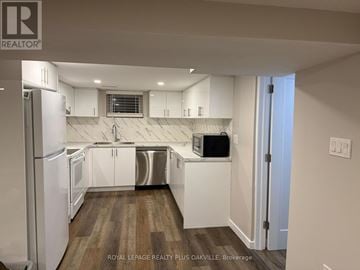 Hamilton (Mohawk) apartment for rent - A kitchen with white cabinets and a refrigerator.