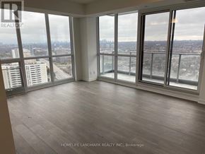 Toronto (Henry Farm) condo for rent - A large, empty room with a view of the cityscape outside the windows.