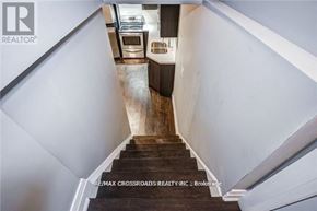 Oshawa (Donevan) apartment for rent - A staircase with a wooden handrail leads to a kitchen area.