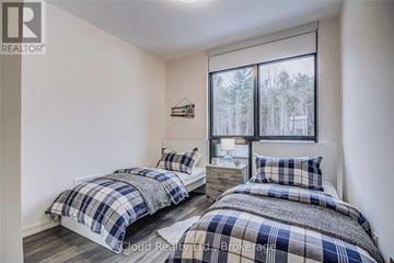 Innisfil townhouse for rent - Two bedrooms with blue and white bedding in a real estate listing.