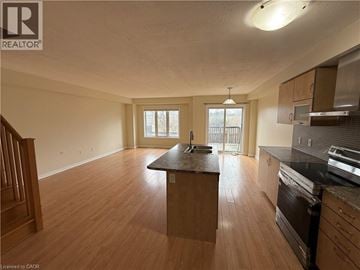 Hamilton apartment for rent - A kitchen with wooden floors and a large island in the middle.
