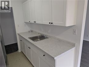 Burlington apartment for rent - A kitchen with white cabinets and a marble countertop.
