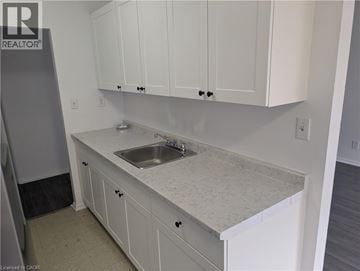 Burlington apartment for rent - A kitchen with white cabinets and a marble countertop.