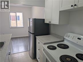 Burlington apartment for rent - A kitchen with white cabinets and a white stove top oven.