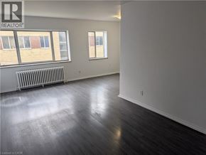 Burlington apartment for rent - A spacious room with wooden floors and white walls.