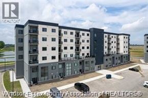 Lasalle condo for rent - A modern apartment complex with a parking lot in front.