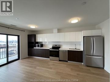 Lasalle condo for rent - A kitchen with a refrigerator, sink, and microwave.