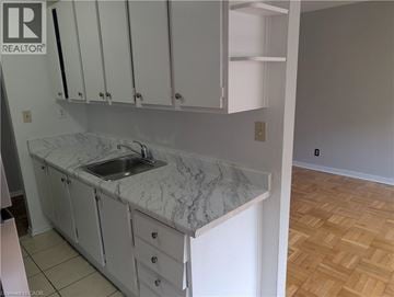 Burlington apartment for rent - A kitchen with white cabinets and a marble countertop.