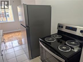 Burlington apartment for rent - A black stove top oven with four burners and a silver refrigerator in a kitchen.