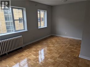 Burlington apartment for rent - A room with wooden flooring and two windows.