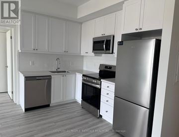 Clarington (Bowmanville) condo for rent - A kitchen with white cabinets and stainless steel appliances.