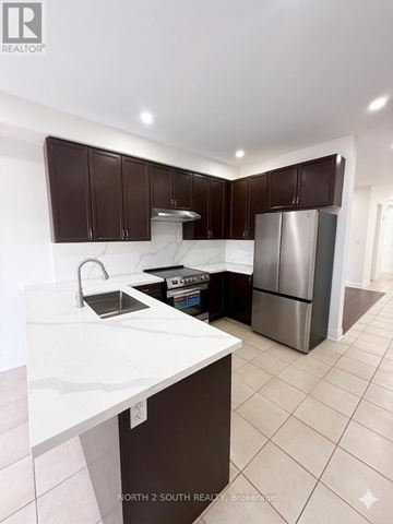 Innisfil (Alcona) apartment for rent - A kitchen with brown cabinets and a white counter top.