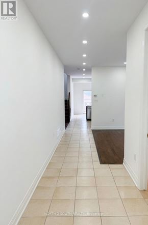 Innisfil (Alcona) apartment for rent - A long hallway with white walls and tiled flooring.