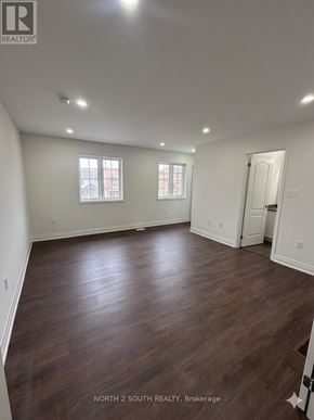 Innisfil (Alcona) apartment for rent - A spacious room with wood flooring and two windows.
