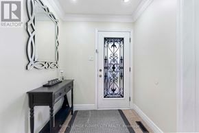 Brampton (Northwood Park) apartment for rent - A hallway with a white door and a mirror on the wall.