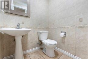 Brampton (Northwood Park) apartment for rent - A white toilet sits next to a pedestal sink in a tiled bathroom.