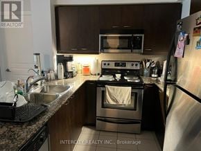 Toronto (Willowridge-Martingrove-Richview) condo for rent - A kitchen with a stove, microwave, and refrigerator.