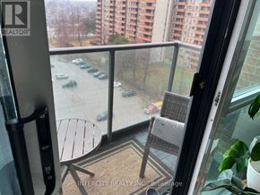 Toronto (Willowridge-Martingrove-Richview) condo for rent - A balcony with a table and chairs overlooking a parking lot.