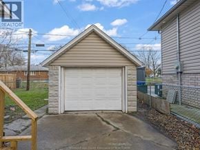 Windsor apartment for rent - A detached garage with a white door is situated in a residential area.