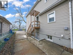 Windsor apartment for rent - A house with a wooden deck and a concrete pathway leading to the front door.