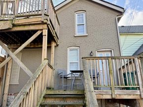Niagara Falls (Downtown) duplex for rent - A house with a deck and a chair on it.