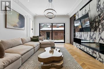 Toronto (Trinity-Bellwoods) apartment for rent - A living room with a beige couch and a coffee table in the center.