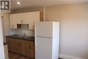 Brantford apartment for rent - A kitchen with wooden cabinets and a white fridge.