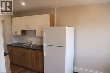 Brantford apartment for rent - A kitchen with wooden cabinets and a white fridge.