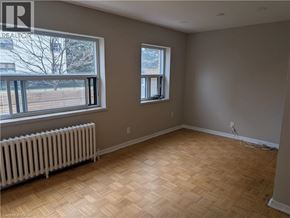 Burlington apartment for rent - A room with wooden flooring and two windows.
