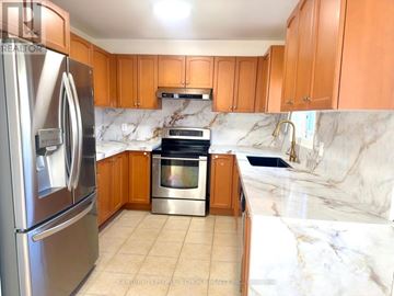 Newmarket (Woodland Hill) townhouse for rent - A kitchen with a refrigerator, oven, and cabinets.