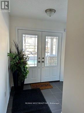 New Tecumseth (Alliston) apartment for rent - A white door with a glass window is flanked by two windows on either side.