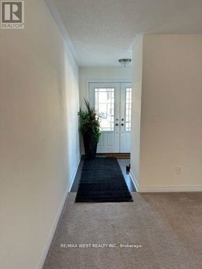 New Tecumseth (Alliston) apartment for rent - A hallway with a plant on the left and a door on the right.